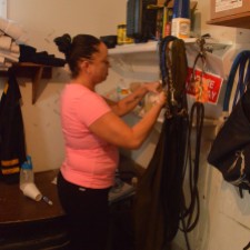 Sarah O'Callaghan cleans the horse's tack to begin a long day of training. Taken Feb. 2015, Gulfstream Racetrack. Photo by: Laura O'Callaghan